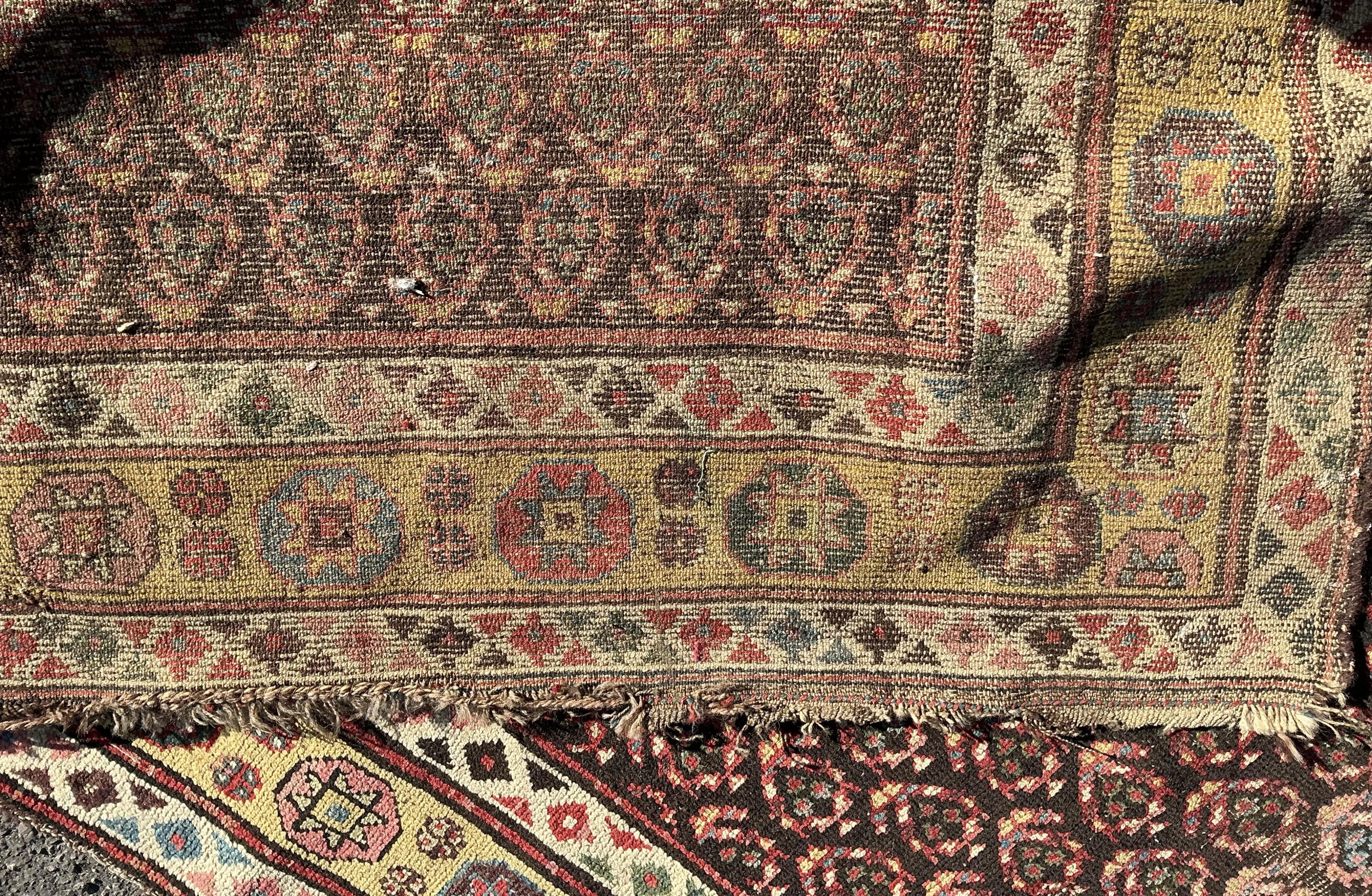 An antique Senneh red ground hall carpet, 325 x 128cm